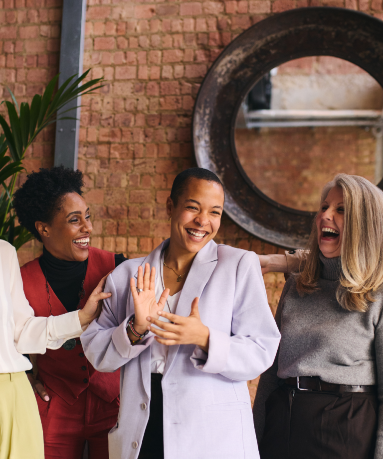 A group of women laughing and enjoying each other's company, representing the importance of support and connection in maintaining good health.